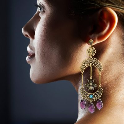 These earrings are made from Swarovski teardrops and have a handcrafted filigree design. The finish is antique bronze and adds elegance to formal outfits. They are lightweight and make a statement with their significant design. The teardrop-shaped Swarovski crystals add a touch of glamour and sparkle to these earrings, making them a must-have accessory for any occasion. Whether you're dressing up for a night out or keeping it casual for a day of shopping, these earrings will elevate your look with their sophisticated style. The crescent filigree design is handcrafted with great care and attention to detail, ensuring that these earrings are not only beautiful, but also durable and long-lasting. The Madonna medallion and fly charm add a unique touch, making these earrings a true one-of-a-kind piece. The super lightweight design makes these earrings comfortable to wear for extended periods of time, so you can rock your look with confidence all day long. Whether you're heading to a formal event or just running errands, these earrings are sure to make you feel fabulous. So if you're looking for a stylish and sophisticated accessory that will turn heads, these handcrafted crescent filigree Swarovski teardrop earrings are the perfect choice. So dare to dangle and make a statement with your style today!