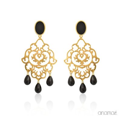 These elegant earrings are made from brass and 24k gold-plated. The intricate filigree motifs used in their design make them look like lace. The studs are oval and feature a combination of gold and black. The gold surface of the studs is covered with a glossy enamel coating, giving them a polished finish. The filigree motifs are adorned with three black teardrops, which add a touch of movement. The luxurious gold plating contrasts beautifully with the striking black enamel and teardrops, making these earrings suitable for any formal occasion. With their sophisticated and elegant appearance, these earrings are a versatile accessory that will complement any outfit.
