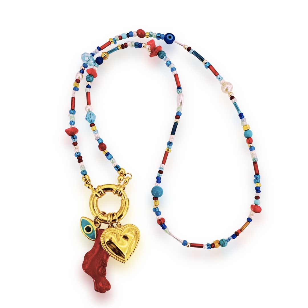 Alcmene is a stunning charm necklace, a celebration of the sea and its treasures! Featuring Miyuki beads, sparkling Swarovski crystals, natural red coral chips, and protective Millefiori evil-eye beads. It's a captivating piece that reflects the sun and the ocean's depths. The chunky marine clasp and removable 24k gold-plated charms add a touch of luxury. They include a turquoise enameled evil-eye charm, a sweet gold heart, and a natural red coral branch. The Miyuki bead chain measures 55 cm long, making it ideal for layering.