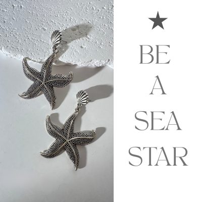 These are bold, statement-making drop earrings designed to evoke the ocean’s edge: • Shape & Motif: Each earring features a five-armed starfish form, rendered in silver-tone metal with a raised, granulated texture that mimics the natural bead-like surface of a real starfish. • Stud Detail: The starfish drops hang from a small, ridged seashell stud—tying the whole seaside theme together while keeping the earring anchored neatly at the earlobe. • Finish & Feel: A bright, polished silver finish lends a modern twist to the vintage–inspired texture; they catch light with every turn, making them perfect for both beach-themed occasions and adding unexpected flair to minimalist outfits. • Size & Statement: These aren’t your “subtle stud” earrings—at roughly 6 cm in length, they demand attention and pair best with swept-back hair or up-dos to let that starfish silhouette shine.