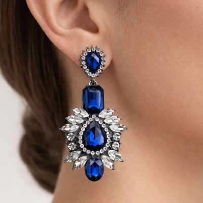 On a woman’s ear Selene statement earrings worn on a woman’s ear showing an elegant drop design Profile side view Selene crystal statement earrings worn with hair pulled back for an evening look.