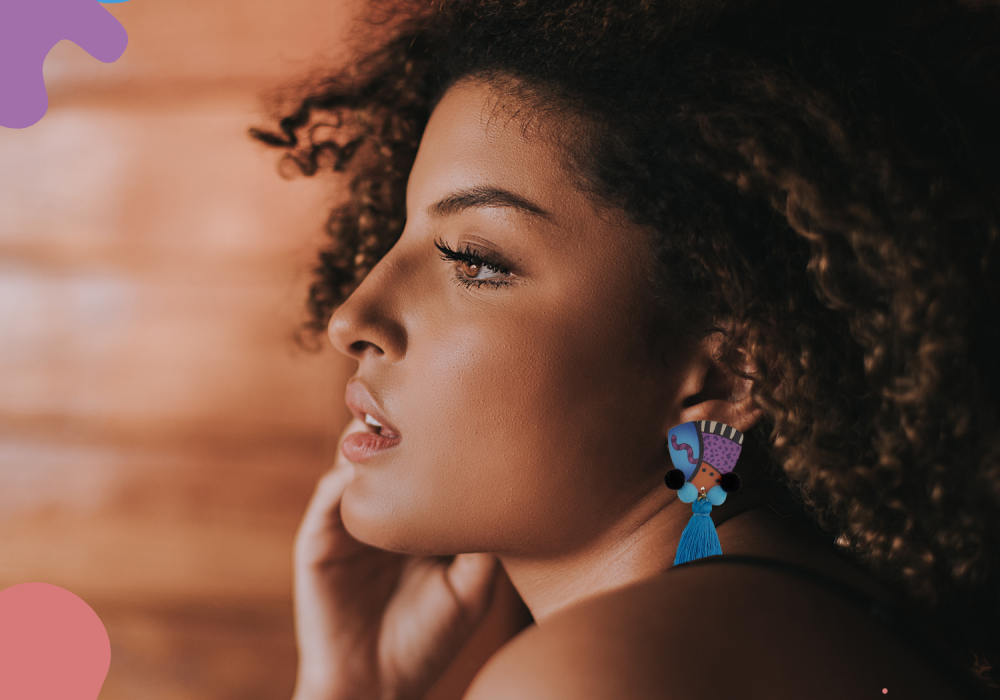 These ethnic earrings showcase a unique blend of vibrant colors and traditional elements. The earrings feature a wooden stud with a colorful ethnic print, adding an earthy and natural touch to the overall design. The stud is decorated with intricate patterns and hues that represent a rich cultural heritage. Dangling beneath the stud are two sets of pompoms, one in light blue and the other in black. A refreshing and calming element is added to the earrings by the blue one. The black pompom provides a striking visual contrast. To further enhance the elegance of these earrings, a silk blue tassel gracefully hangs from the pompoms. The silk tassels are in a vibrant shade of blue, adding a luxurious and refined touch to the overall design. The combination of the wooden stud, light blue and black pompoms, and blue tassels creates a visually captivating piece of jewelry. These earrings are not only a fashion statement but also a representation of diverse cultures and traditions. They beautifully combine different materials and colors, making them a unique accessory to complement any ethnic or contemporary outfit